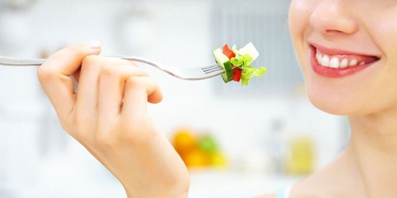 Meisje eet groentesalade en valt af met haar favoriete dieet