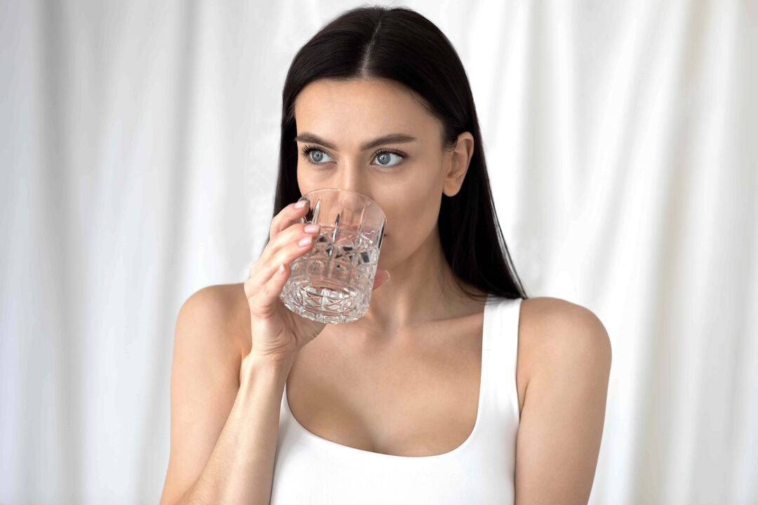 meisje drinkt water om af te vallen met de juiste voeding